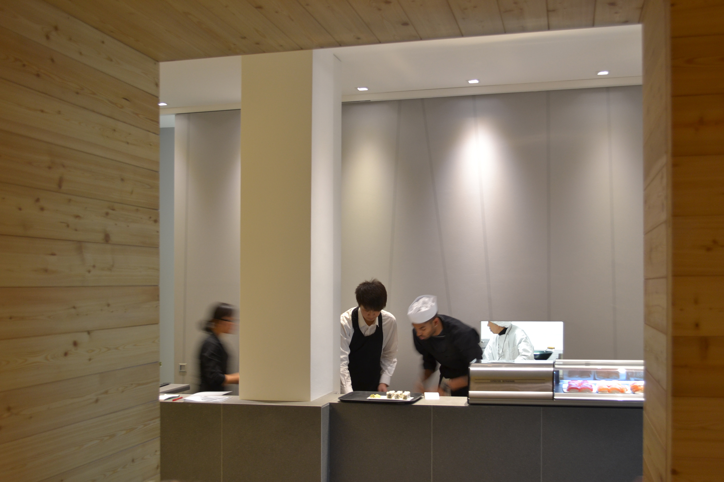 Foto di iKKi Sushi Restaurant a Conegliano Veneto. Veduta interno bancone con personale. Progetto di Machina Architetti Associati, 2011